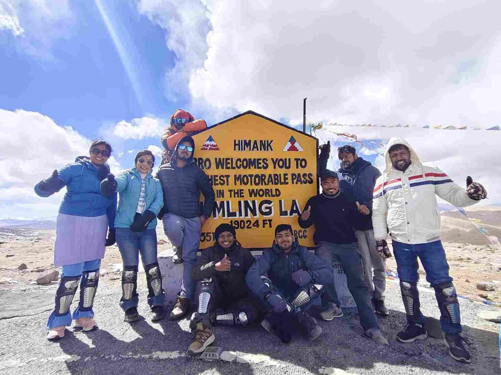 Group of bikers enjoying scenic views of Umling la on a budget-friendly Ladakh bike trip