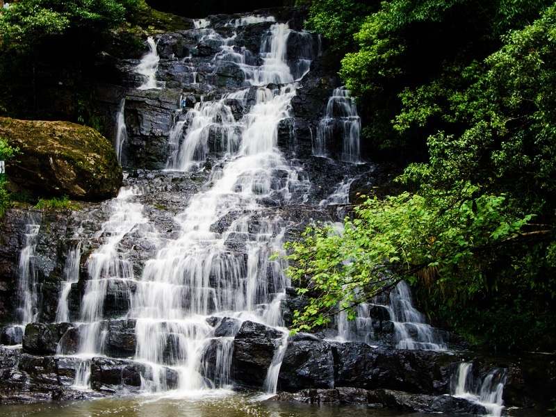 Multi-tiered flow of Elephant Falls with stone steps and viewing platforms